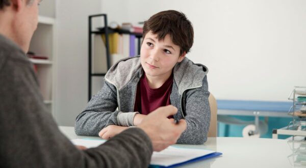 Teen boy listening to an adult