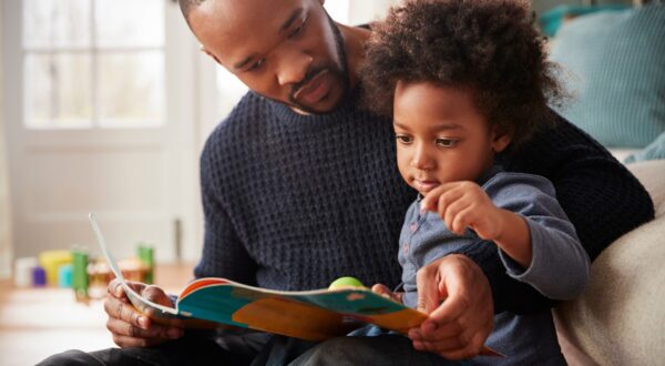 A father reads a book with a child