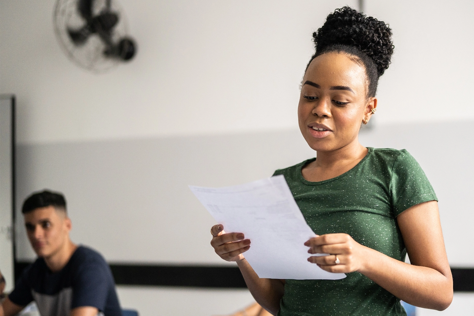 Young adult reading from a piece of paper
