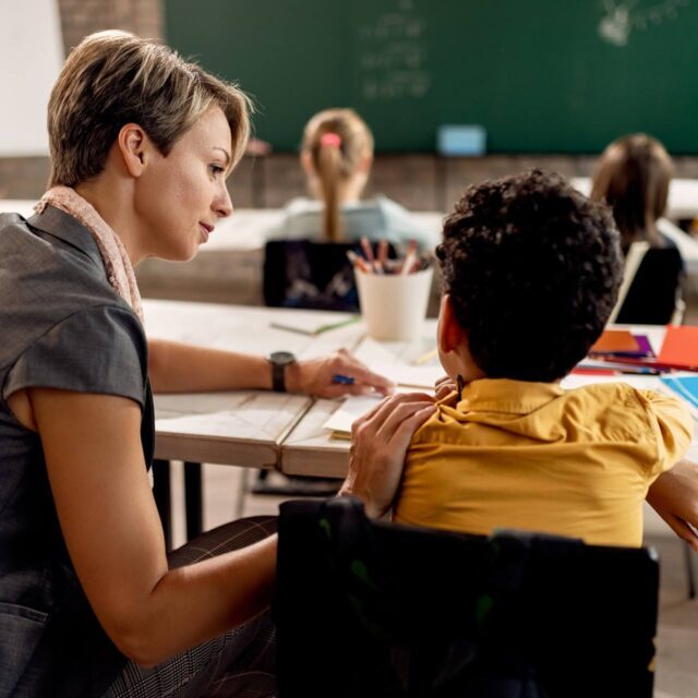 Female teacher working with young male student