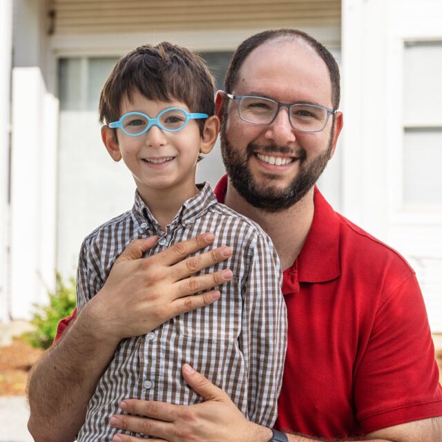 A father and his son, who is a Stern Center student, stand outside of the Stern Center building