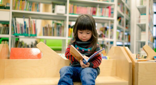 Young girl reading in library