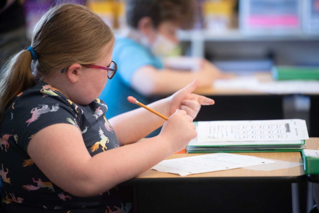 Young girl student counting using her fingers