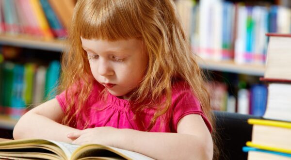Young red headed girl reading