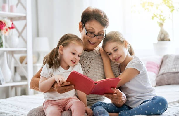 Older woman with two girls reading