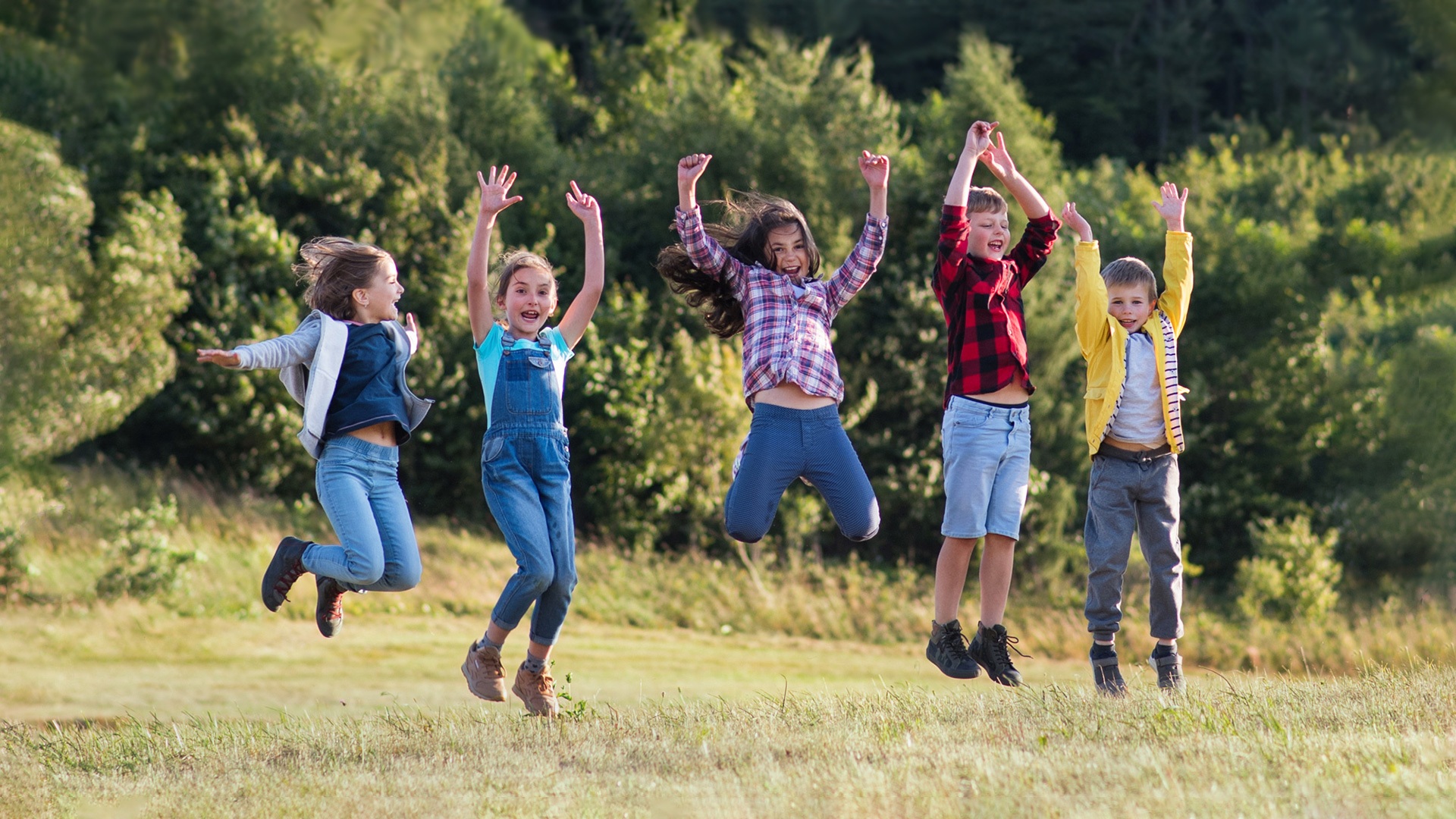 Group of kids jumping in a field