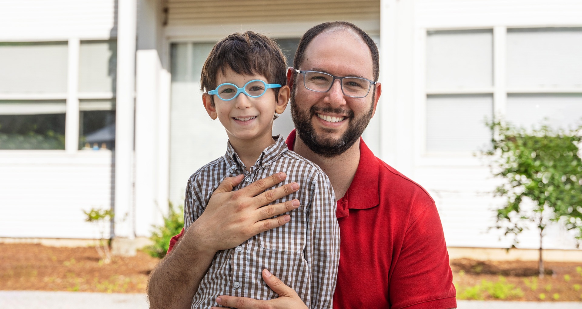 A father and his son, who is a Stern Center student, stand outside of the Stern Center building