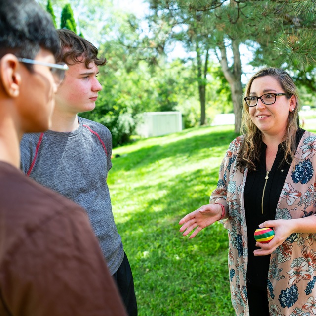 A speech-language pathologist teaches perspective-taking and turn-taking with two students.