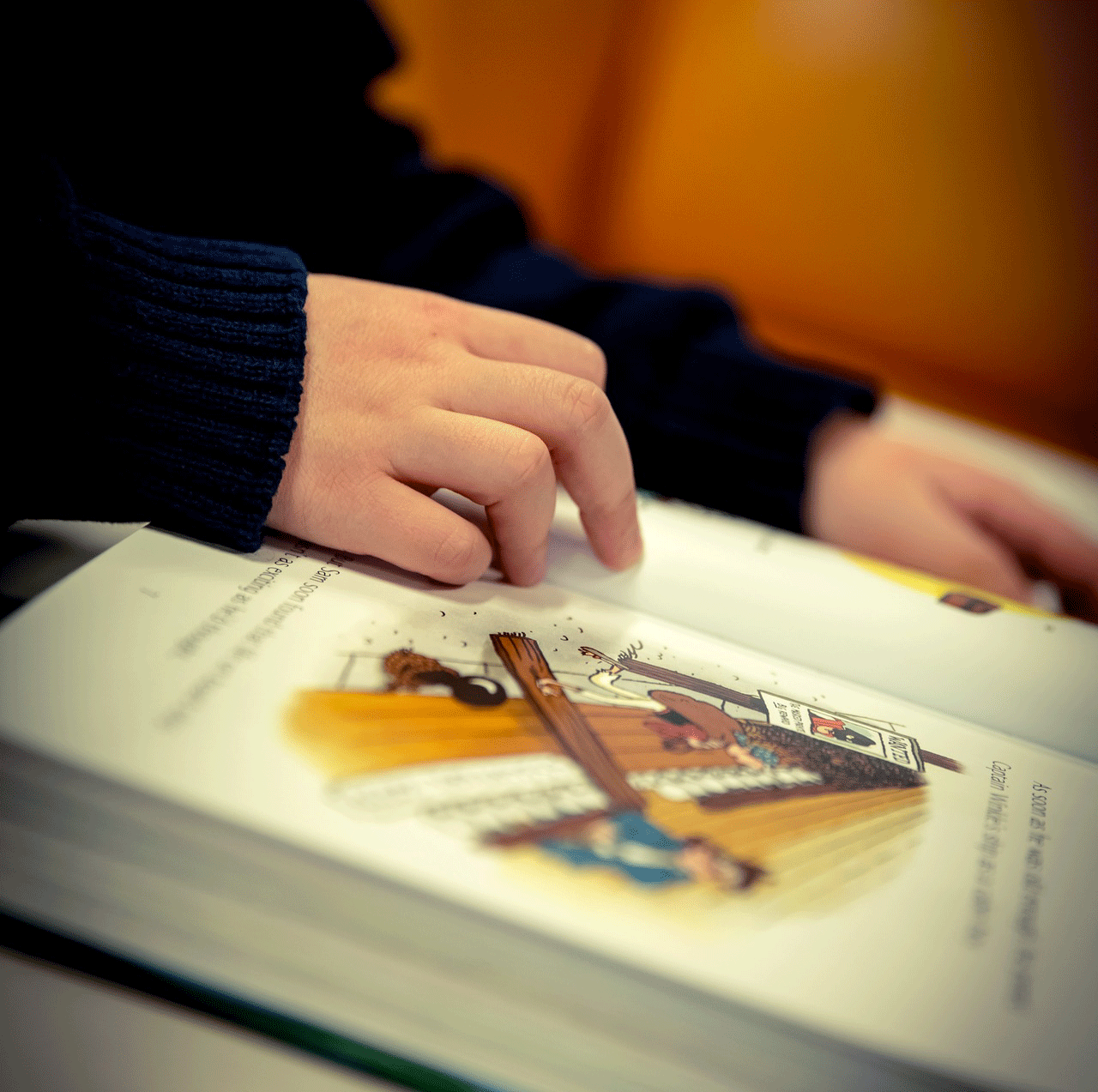 child's hand on book