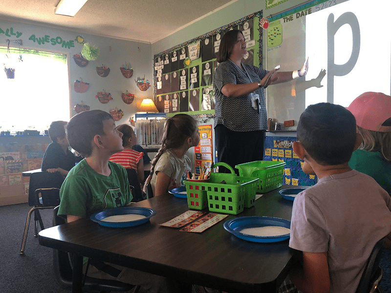 teacher in front of students teaching the letter P