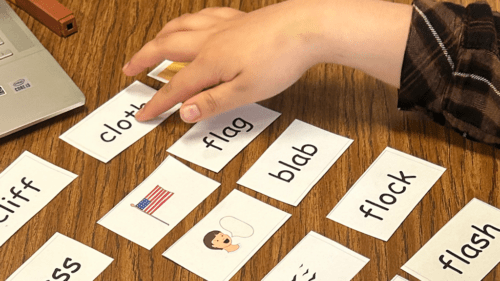 hand pointing to word cards