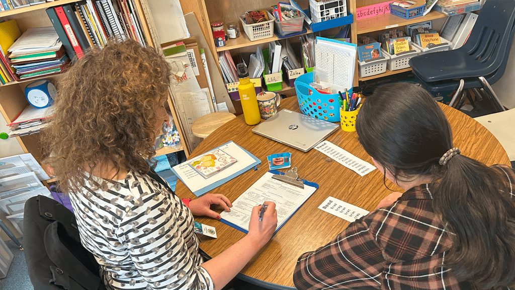 teeacher working with student at desk
