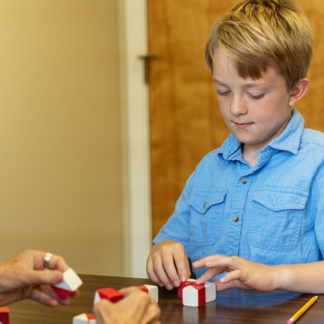 Young boy arranging blocks as part of a psycheducational evaluation