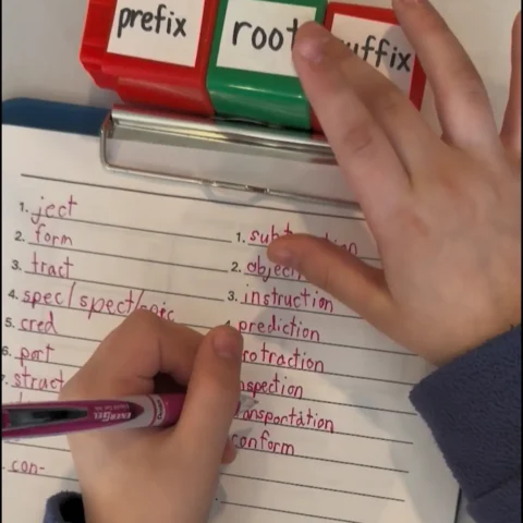 Child's hands writing on paper