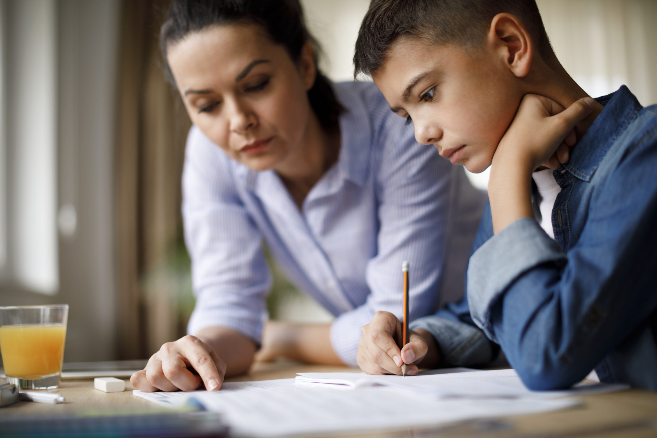 A mother helps her son with homework