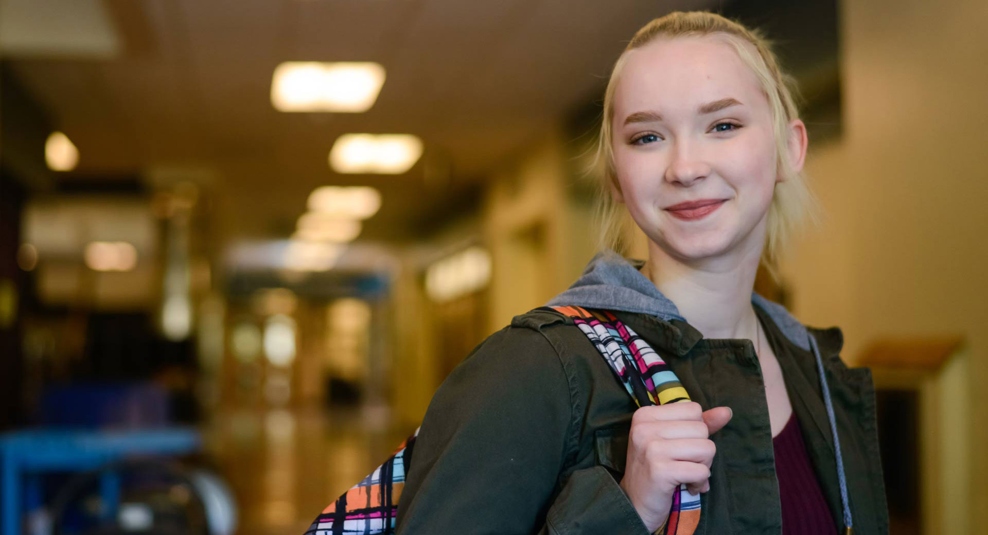 Smiling teenager in high school hallway